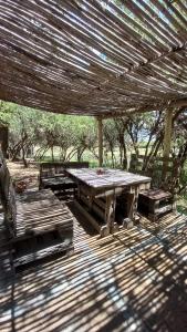 una mesa de picnic y sillas bajo un techo de madera en La Residencial en Humahuaca