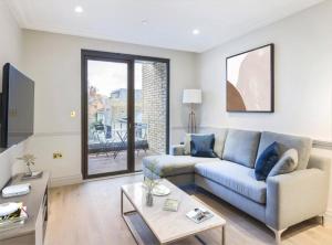 a living room with a couch and a table at Modern Hammersmith Bridge Flat in London