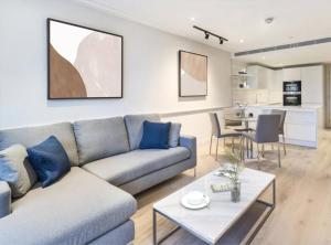 - un salon avec un canapé et une table dans l'établissement Modern Hammersmith Bridge Flat, à Londres