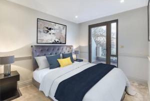 sypialnia z dużym łóżkiem i oknem w obiekcie Modern Hammersmith Bridge Flat w Londynie