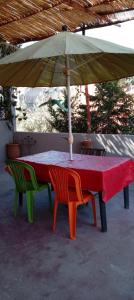 una mesa y dos sillas bajo una sombrilla en Maison vallée de l'Ourika en Marrakech