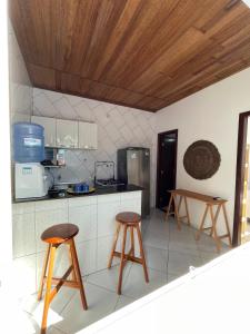 a kitchen with two stools and a counter top at Small house in Ilha de Boipeba