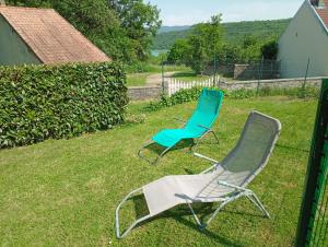 two chairs sitting in the grass in a yard at Gite du bourbouillon in Largillay-Marsonnay