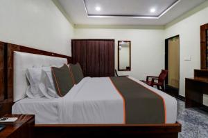 een slaapkamer met een groot bed, een bureau en een stoel bij Collection O B SQUARE VILLA in Visakhapatnam