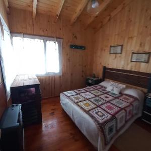 ein Schlafzimmer mit einem Bett und einem Herd in einer Hütte in der Unterkunft Cabañas Los Ñires in Moquehue