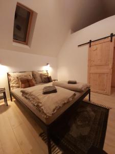 een groot bed in een kamer met een houten deur bij Ponad Górami in Gliczarów Górny