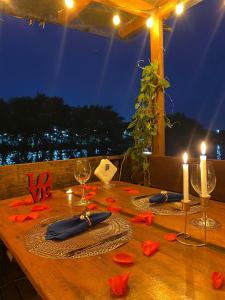 una mesa de madera con dos velas y flores rojas. en Casanova Residence, en Río de Janeiro
