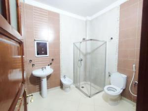 a bathroom with a shower and a toilet and a sink at SkyRise Khemisset 2 : 2 bedrooms in Khemisset