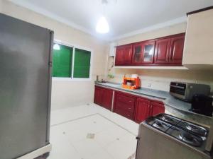 a kitchen with red cabinets and a stove in it at SkyRise Khemisset 2 : 2 bedrooms in Khemisset