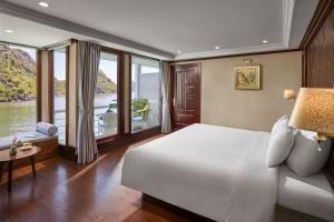 1 dormitorio con 1 cama blanca grande y ventanas grandes en Lotus Luxury Cruise, en Ha Long