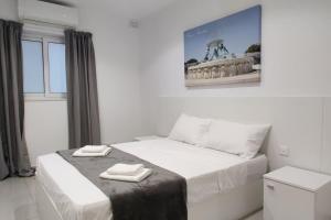 um quarto com uma cama com duas toalhas em Apt B : Fun flat for up to 5+ Inc terrace em Is-Swieqi