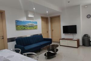 uma sala de estar com um sofá azul e uma televisão em Apt B : Fun flat for up to 5+ Inc terrace em Is-Swieqi
