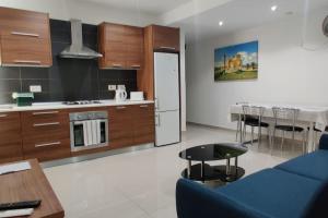 uma sala de estar com um sofá azul e uma cozinha em Apt B : Fun flat for up to 5+ Inc terrace em Is-Swieqi