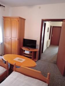 a living room with a table and a tv and a room at Prenoćište San Rooms in Livno