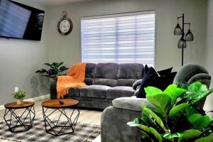 ein Wohnzimmer mit einem Sofa und einer Uhr an der Wand in der Unterkunft Comfortable Family Home in Las Vegas
