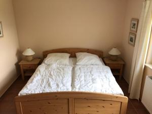 a bedroom with a bed with two nightstands and two lamps at Dycke Haus 6 in Zudar