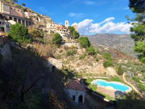 un village sur une colline avec une piscine dans l'établissement A Casa da Nonna Brasa Holiday Home Savoca, à Savoca