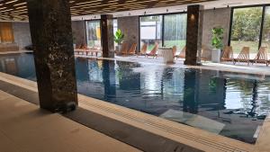 a swimming pool in a hotel with chairs at Sunny Mountain Apartment - Zlatibor, Serbia - SPA & WELLNESS CENTER in Zlatibor