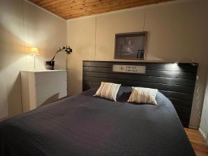 um quarto com uma cama grande e uma cabeceira em madeira em Tirmo Strand em Porvoo