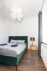a bedroom with a green bed and a lamp at Urige Wohnung mit zwei Betten und genialer Küche in Mügeln