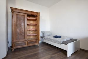 a bedroom with a bed and a wooden cabinet at Urige Wohnung mit zwei Betten und genialer Küche in Mügeln
