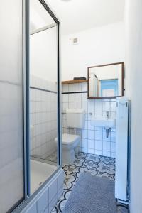 a bathroom with a toilet and a sink and a mirror at Urige Wohnung mit zwei Betten und genialer Küche in Mügeln