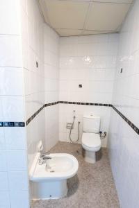 a white bathroom with a toilet and a sink at Avantha By Afi luxury 2BHK apartment in Dubai
