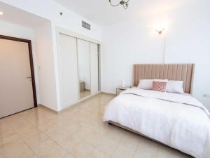 a white bedroom with a bed and a tiled floor at Avantha By Afi luxury 2BHK apartment in Dubai