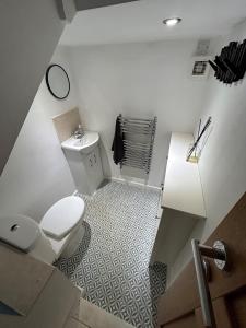 La salle de bains blanche est pourvue de toilettes et d'un lavabo. dans l'établissement Millwright Villa - sleeps 7, à Lincolnshire