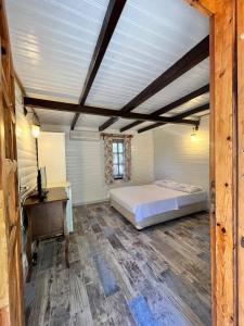 1 dormitorio con 1 cama y escritorio en una habitación en Kızılbük Ahşap Evleri en Datca