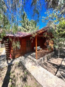 a log cabin with a porch in the woods at Kızılbük Ahşap Evleri in Datca