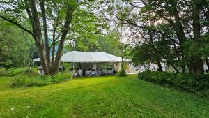 une tente blanche avec des personnes assises dans un parc dans l'établissement Vacation home/Cottage on Private 20 Acres Land - Resort-a/Spa Cottage, à Cookstown
