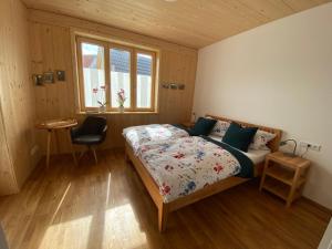 a bedroom with a bed and a desk and a chair at Übernachtung beim Bio-Metzger "Zimmer Rosl" in Mössingen
