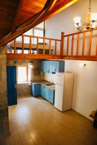 a kitchen with blue cabinets and a white refrigerator at Kızılbük Ahşap Evleri in Datca