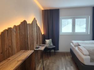 1 dormitorio con 1 cama y una valla de madera en Pension fein & sein en Schwarzsee