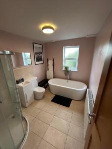 a bathroom with a tub and a toilet and a sink at Millwright Villa - sleeps 7 in Lincolnshire