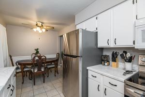 a kitchen with a stainless steel refrigerator and a table at 2 Bedroom Oasis 5 Mins to Mayo Clinic in Rochester