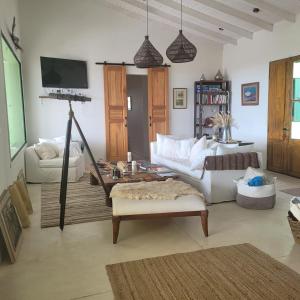 a living room with a white couch and a tv at Casona Islas Blancas in Camarones