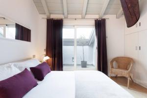 ein Schlafzimmer mit einem Bett mit lila Kissen und einem Fenster in der Unterkunft Como Sweet Como in Como