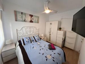 een slaapkamer met een bed en een flatscreen-tv bij Infantes Beach Apartment in Torre del Mar