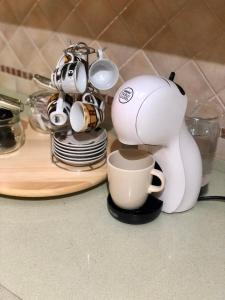 a white coffee maker sitting on a counter with a cup at Casa Sara in Monopoli +2 photos