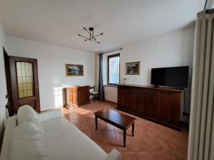 a living room with a white couch and a tv at Sonia sweet home in Candelo