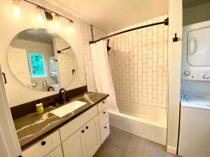 y baño con lavabo y espejo. en Creekside Cottage in the City, en Portland