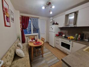 een keuken en een woonkamer met een tafel en een bank bij Уютен 2-стаен Апартамент в Центъра на Добрич in Dobrich