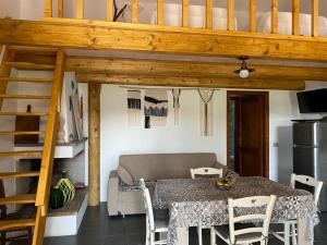 a living room with a table and a loft bed at Casa Margherita in Càbras +30 photos