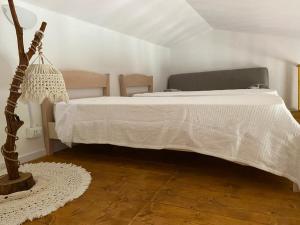 a bedroom with a bed with a white comforter at Casa Margherita in Càbras