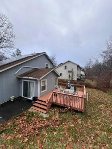 a house with a large deck in a yard at Home sweet home in woods in Tobyhanna