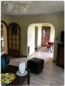 a living room with a couch and a table at Chambre dans maison avec piscine in Brive-la-Gaillarde