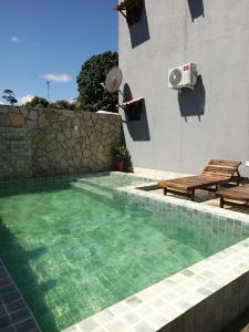 ein Swimmingpool vor einem Gebäude mit einem Haus in der Unterkunft Flat Sonhos de Milagres in São Miguel dos Milagres