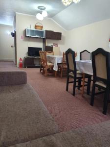 a living room with a table and chairs at CASA LAURENTIU in Borşa